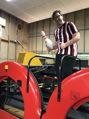 SLES Participant Pat holding a bowling pin at work placement in Horsham