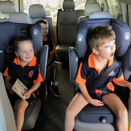 Primary School Students sitting on a bus acting surprised